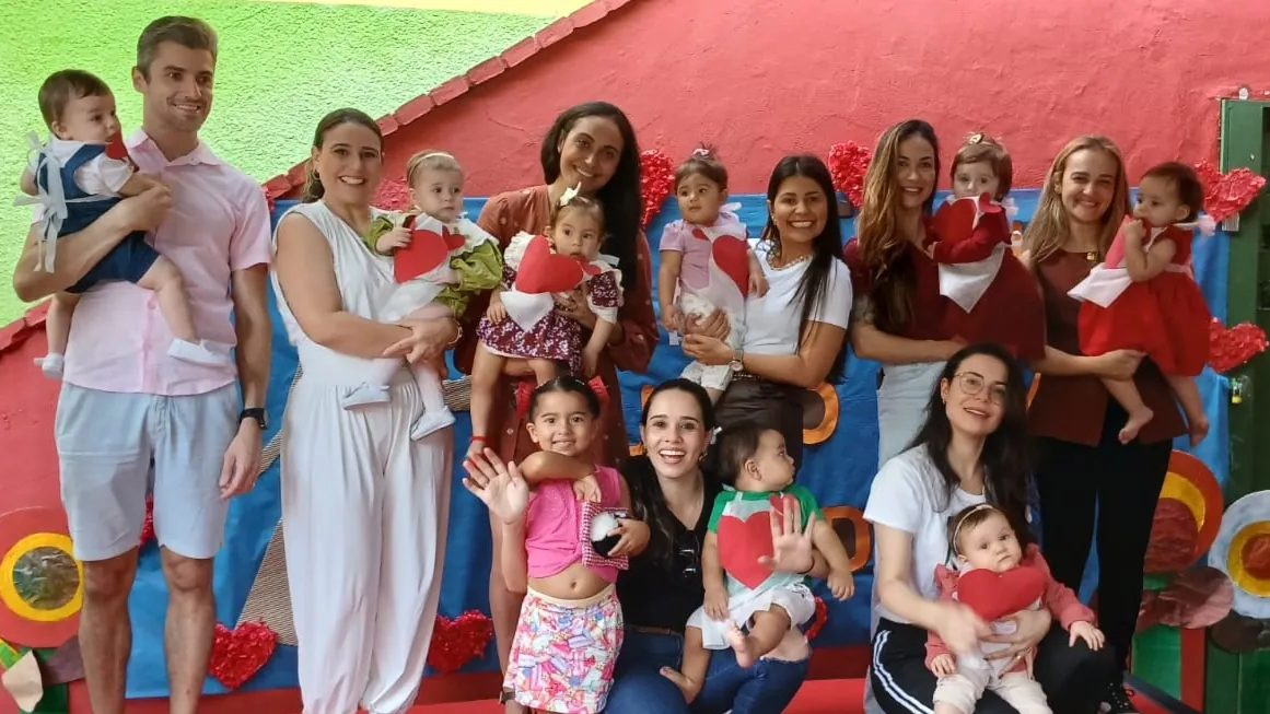Mães e bebês reunidos na comemoração do Dia das Mães da escola